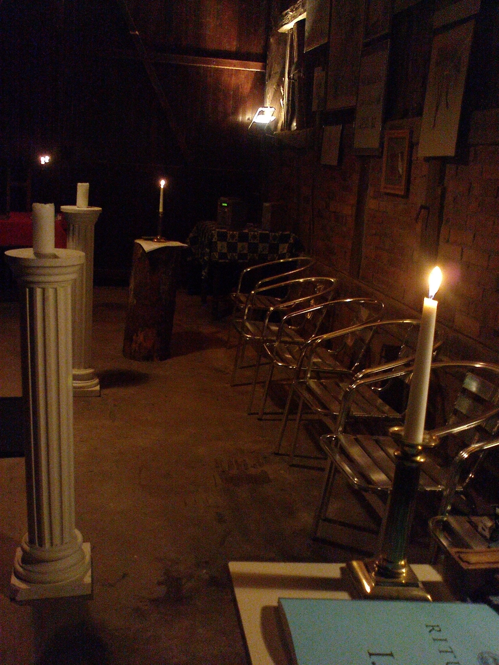 Mutabor ad Lucem - Verein für Freimaurerei - Kerzen auf Säulen und Stühle in einem dunklen Raum